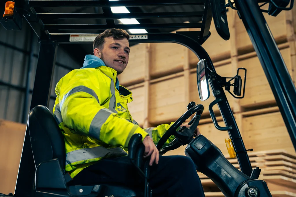 Forklift operator handling export-packed goods inside IM Export Services warehouse.